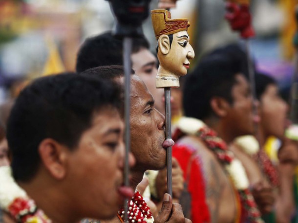 Devotees of the Chinese Bang Neow Shrine with decorated spikes pierced through their tongues, take a part in a procession celebrating the annual vegetarian festival in Phuket