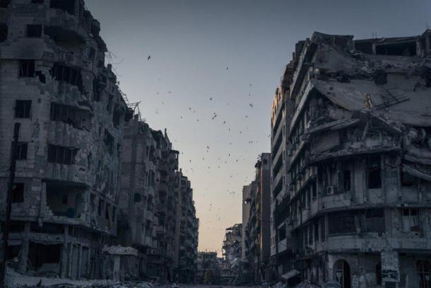 Honorable Mention Places - Homs détruite, Syrie Les oiseaux survolent les maisons détruites dans le district de Khalidiya à Homs, en Syrie. Rien ne bouge. Puis, soudain, le vent souffle un auvent arraché
