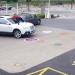 monte sur le capot de sa voiture