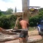 homme seul soulève tronc d'arbre