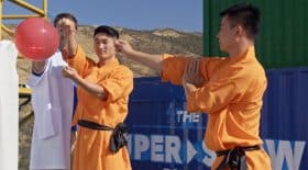 moine Shaolin éclate un ballon derrière une vitre