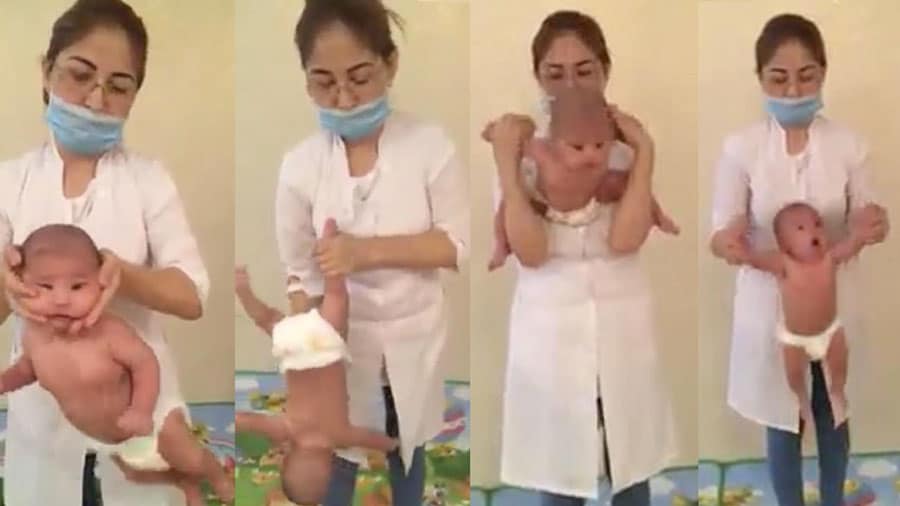 Une Infirmiere Masse Un Bebe En Le Secouant Par Les Pieds Et Par La Tete
