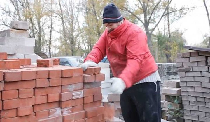 homme casse des briques en deux à la main