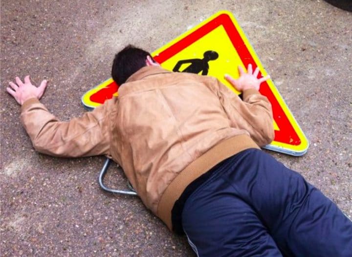Homme tombe sur panneau