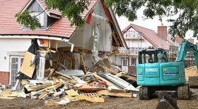 ouvrier démolit des maisons à la tractopelle