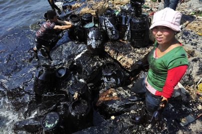 Fishermen clean up oil at an oil spill site near Dalian Port, Liaoning province