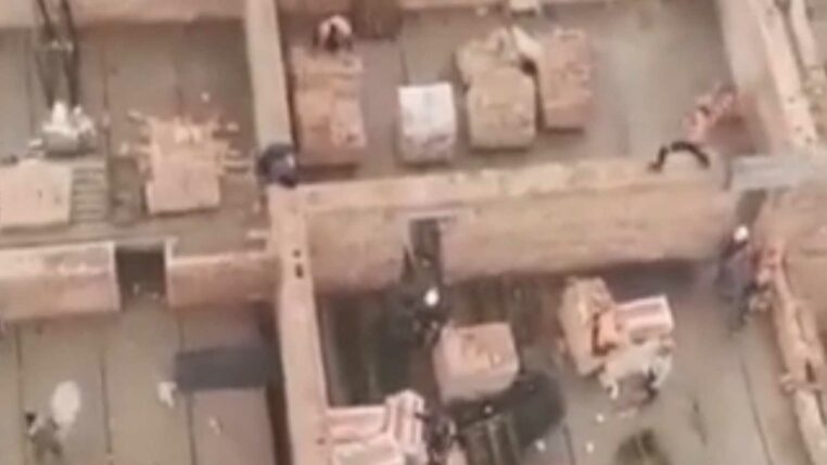 ouvriers sur un chantier lancent briques