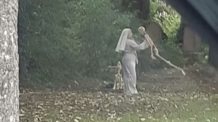 une nonne danse avec un squelette dans un cimetiere