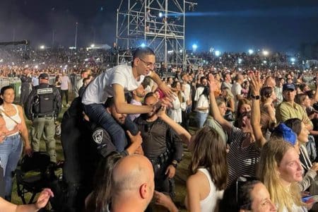 un policier prend un handicapé sur ses épaules dans un concert