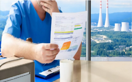 personne-regardant-avec-inquiétude-sa-facture-d'électricité-avec-centrale-nucléaire-en-arrière-plan