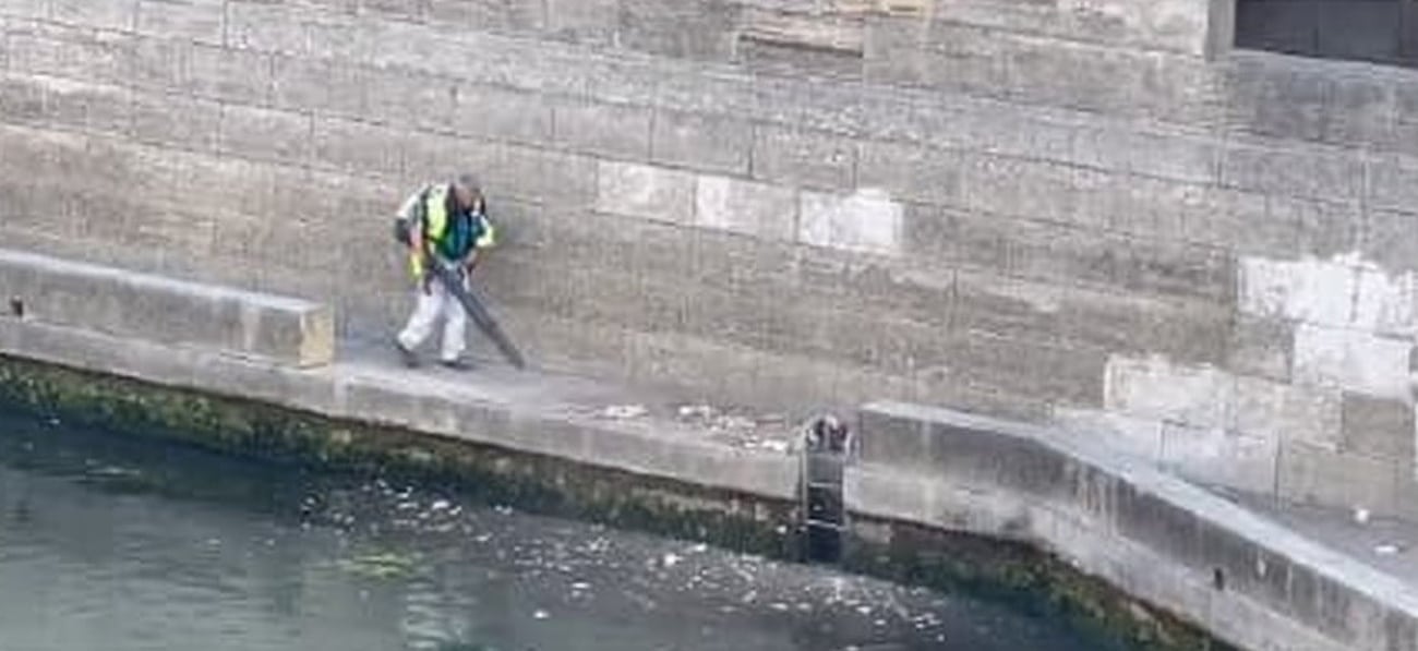 Un agent d'entretien jette ses ordures dans la Seine