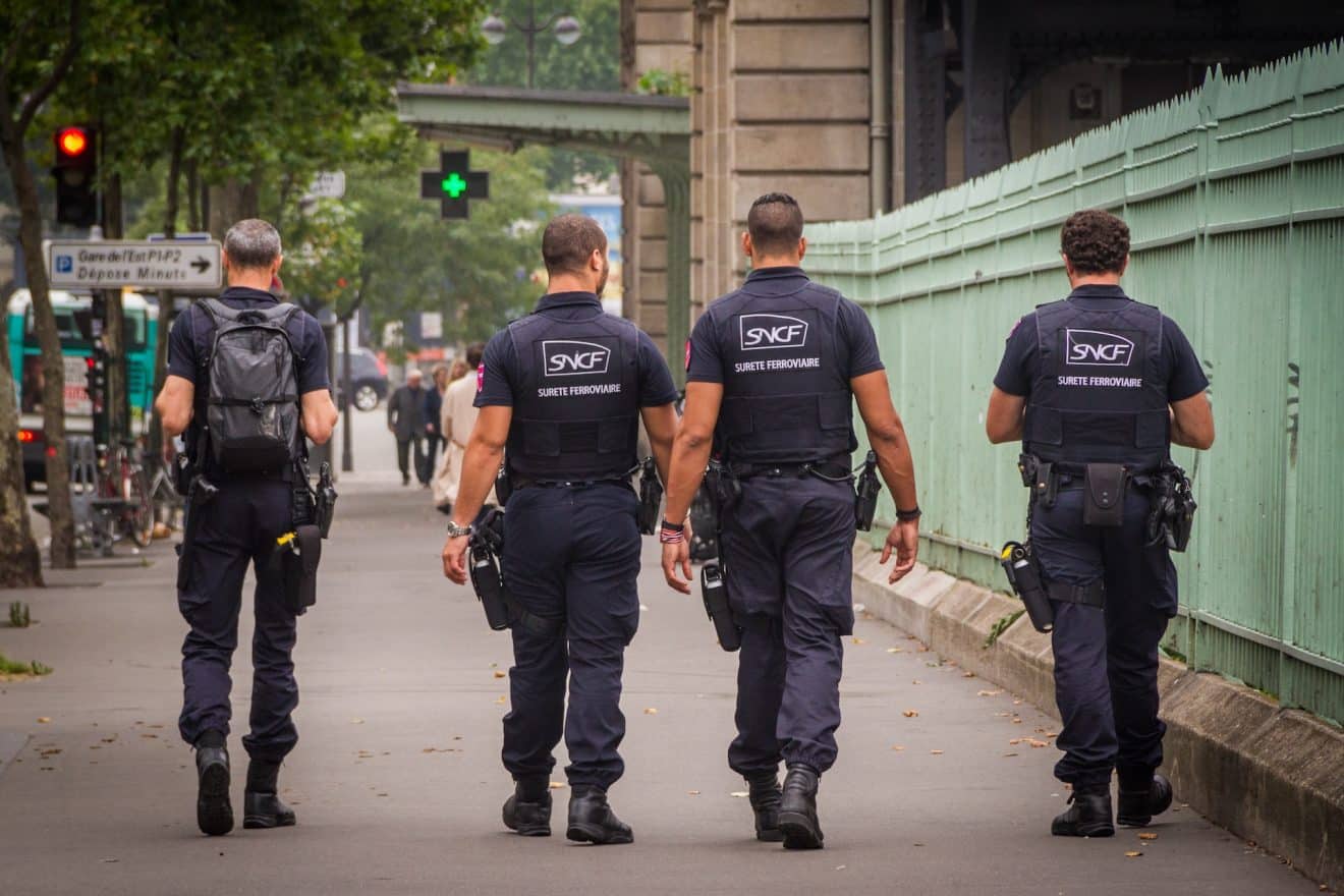 Des policiers de la SNCF marchent près d'une gare pour veiller à la sécurité des usagers.