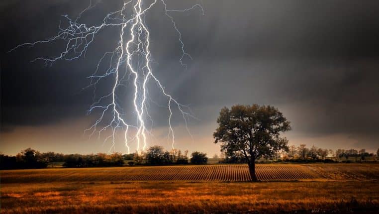 Orage en campagne sous un ciel sombre avec de nombreux éclairs