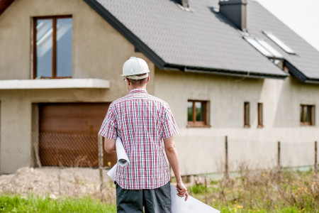 Image illustration un constructeur commence à construire une maison sur le terrain d'à côté.