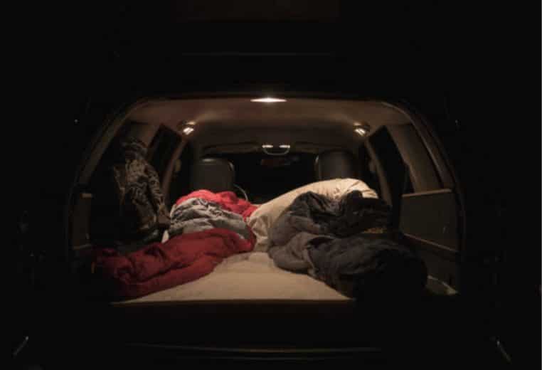 image illustration un homme vole une voiture mais s'endort dedans au lieu de partir.