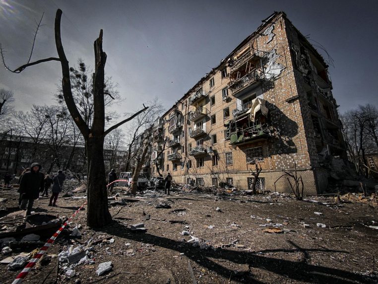 A war-torn residential building in Kyiv, Ukraine, showing significant destruction and debris.