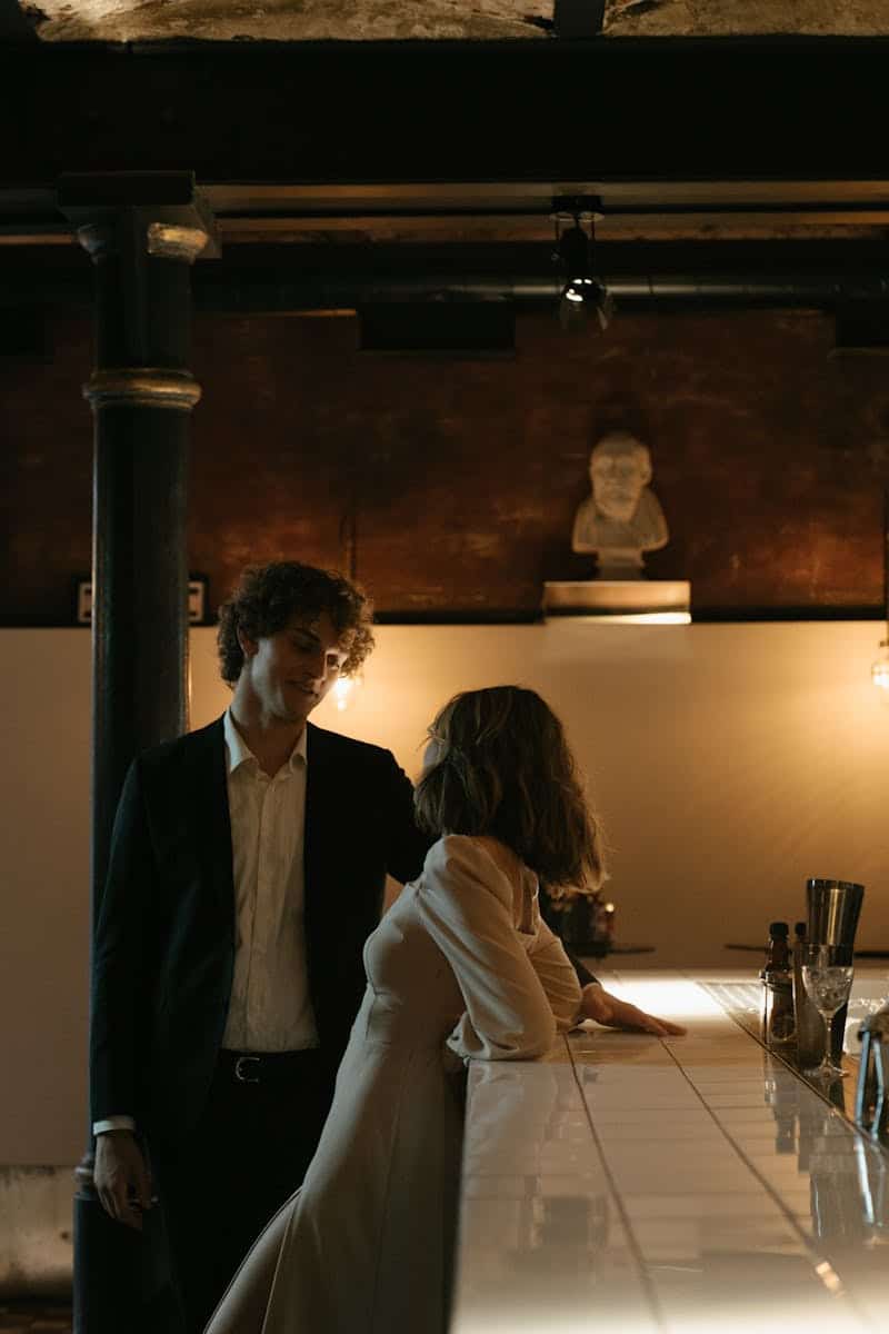 Elegant couple at a dimly lit bar, creating a romantic and intimate atmosphere.