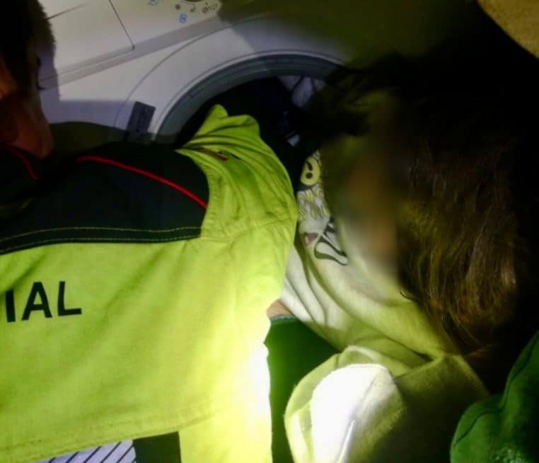 Une petite fille se coince dans la machine à laver