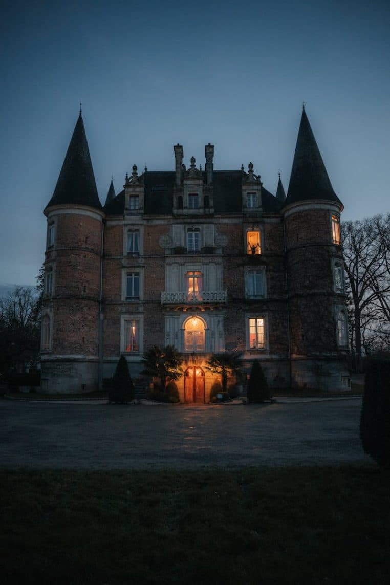 Enchanting illuminated French castle at dusk with towers and elegant architecture.