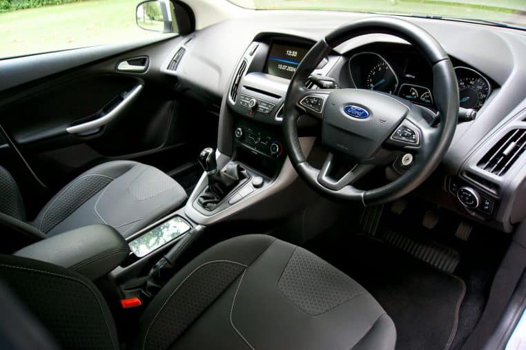 Luxurious car interior featuring sleek dashboard and ergonomic steering wheel.
