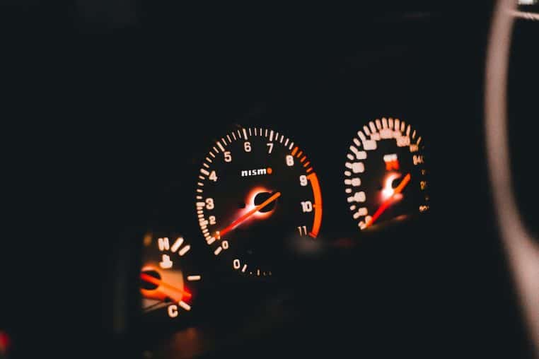 Detailed view of illuminated Nismo car gauges displaying the speedometer and tachometer.