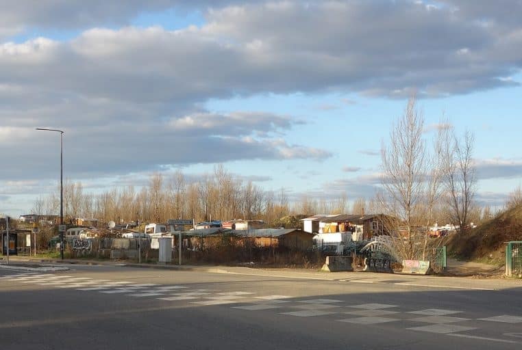 Plusieurs caravanes alignées devant un bâtiment et un ciel dégagé.