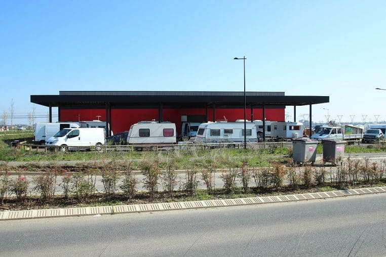 Plusieurs caravanes et roulottes entourant un bâtiment en zone urbaine