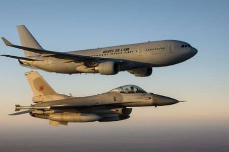 Vue en vol d’un A330 MRTT Phénix français survolant et étant escorté par un F-16C/D Fighting Falcon marocain sous un ciel dégagé.