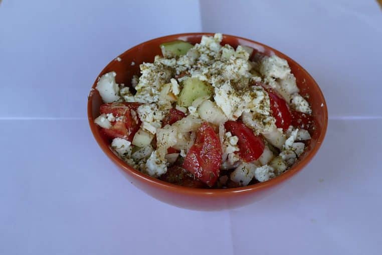 Assiette de salade grecque traditionnelle avec gros morceaux de feta, concombre, tomates et olives.