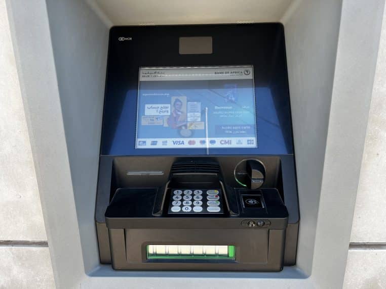 ATM noir et gris de marque NCR avec écran et clavier.