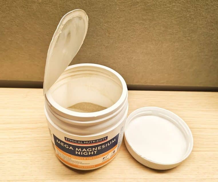 Pot ouvert de comprimés de magnésium blancs