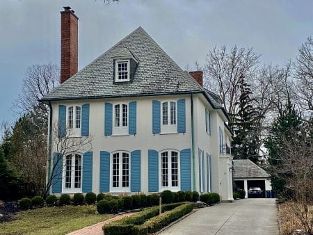 Façade crème avec volets bleus autour des fenêtres