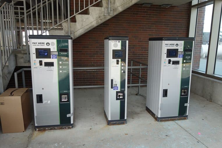 gros plan sur deux automates gris permettant de régler son stationnement, placés sur un quai couvert.