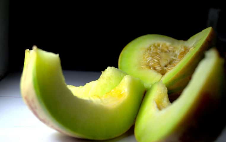 Melon musqué entier posé sur fond neutre.