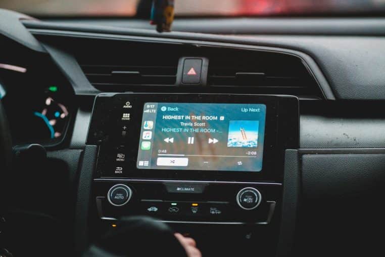 Gros plan sur un écran d’autoradio affichant une chanson dans un habitacle de voiture