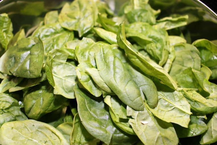 Feuilles d’épinards fraîches sur planche en bois