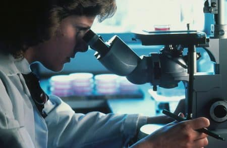 Femme regarde le microscope