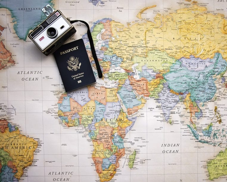 Passeport ouvert sur une carte du monde, globe terrestre en arrière-plan.