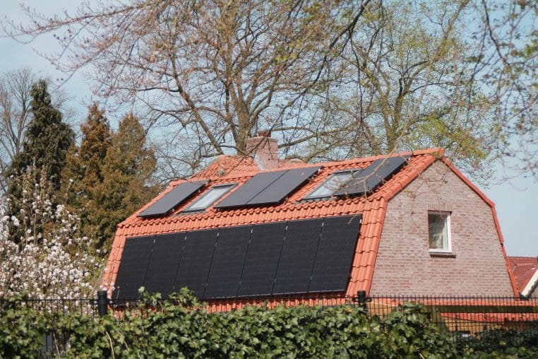 Toit de maison intégrant des panneaux solaires noirs.
