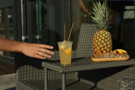 Main tendue vers un verre contenant du liquide