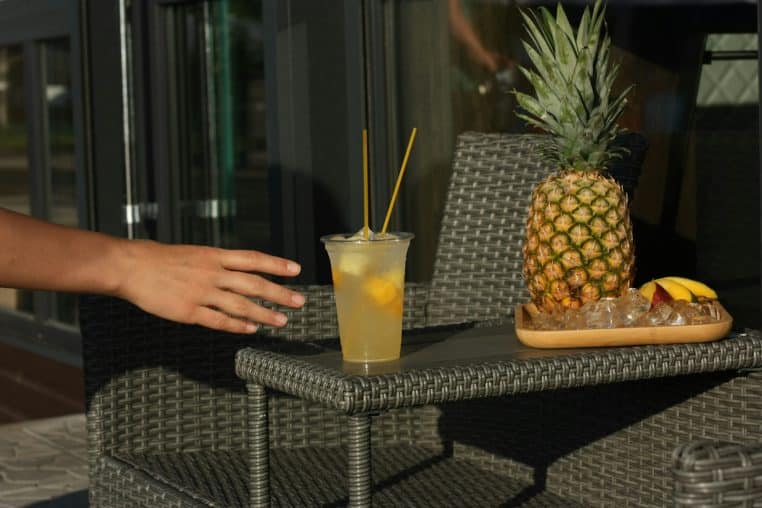 Main tendue vers un verre contenant du liquide