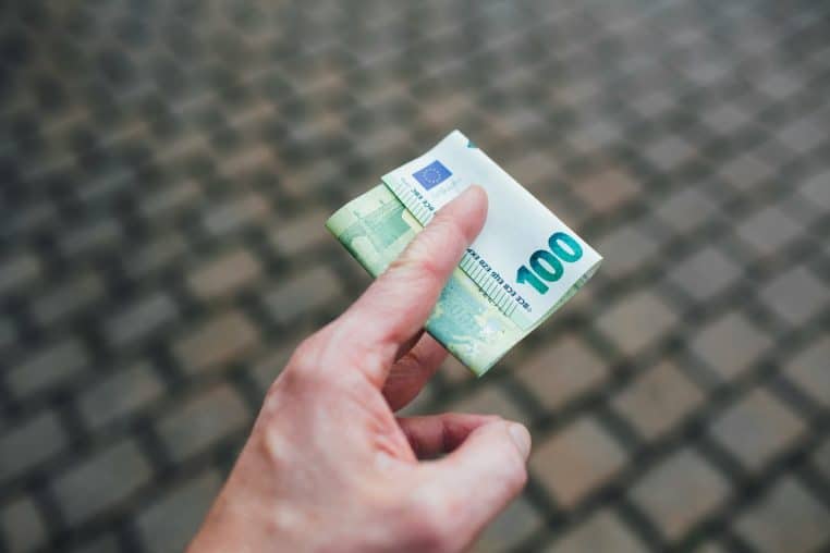Main tenant un billet de 100 euros, paiement en espèces