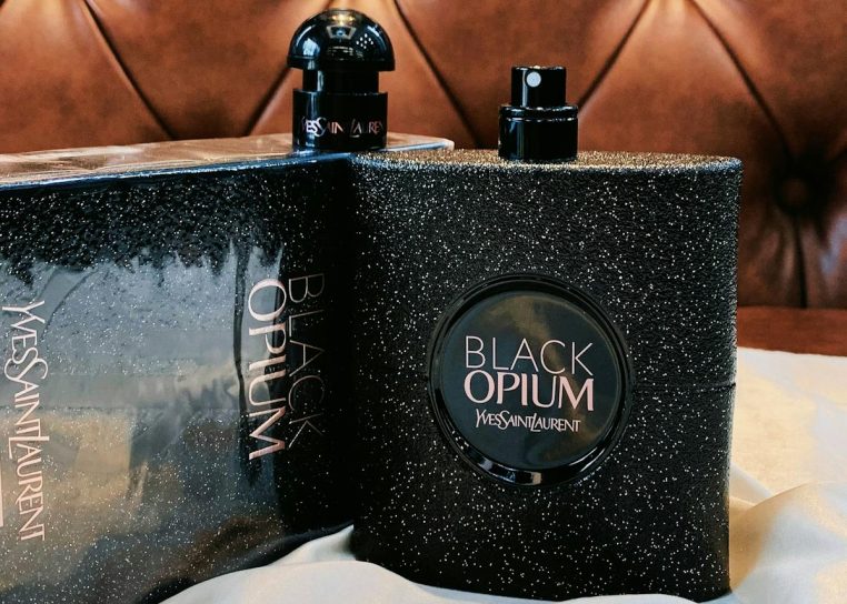 Elegant display of Black Opium fragrance by Yves Saint Laurent on a textured background.