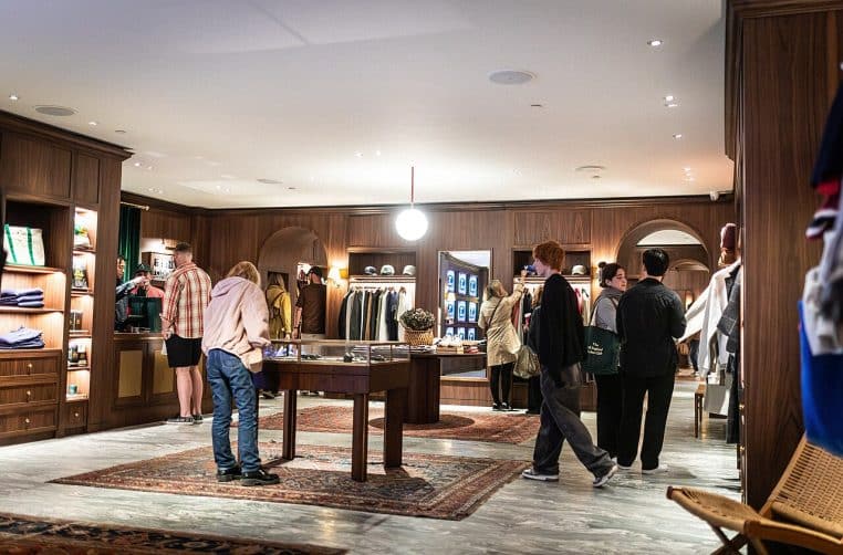 Intérieur d’une boutique de luxe avec étagères en bois et luminaires.