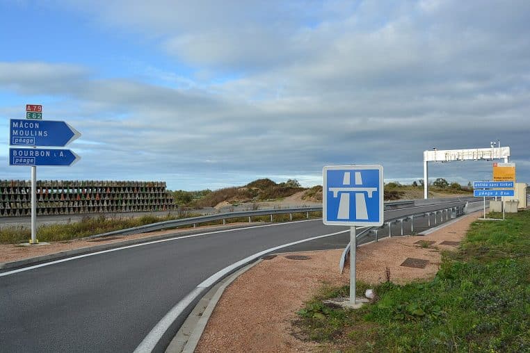 Portique de péage en flux libre sur l’A79, sous un ciel nuageux.