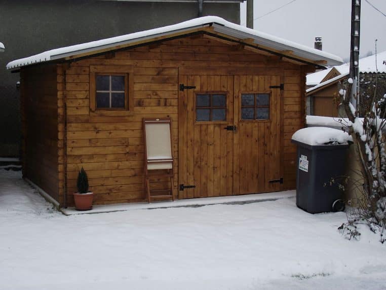 Chalet de jardin couvert de neige.