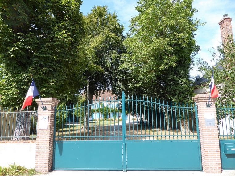 mairie de campagne avec arbres et bancs.