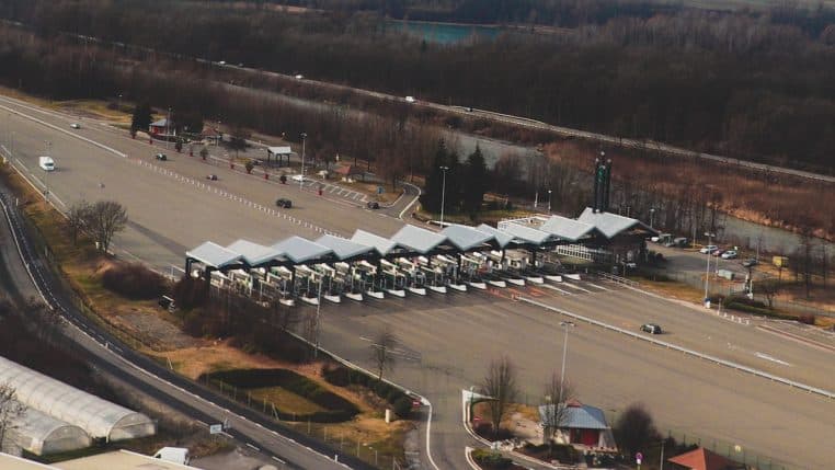 Poste de péage classique en fin d’autoroute, barrières et cabines.