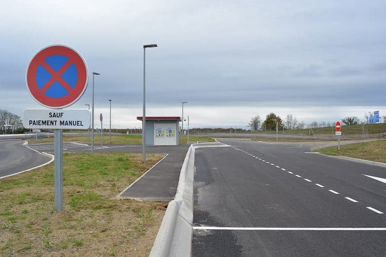 Panneau indiquant “Arrêt interdit sauf paiement manuel” au péage sans barrière.