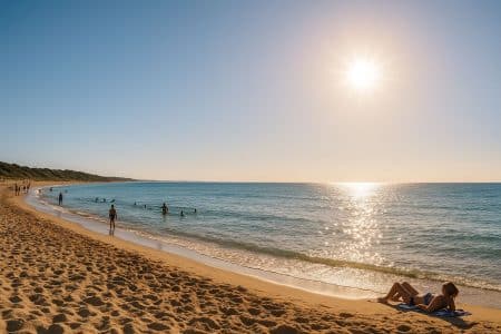 Plage française sous un ciel dégagé avec sable doré et mer calme.